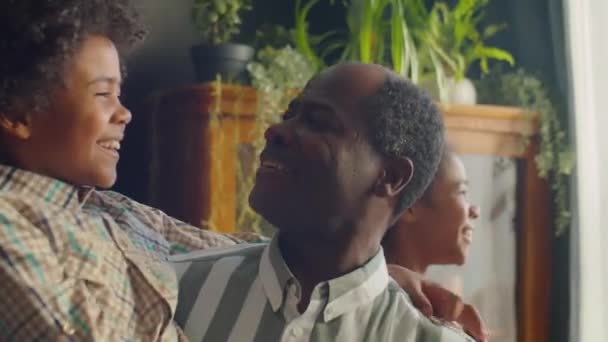 Счастливый Афроамериканец Папа Улыбается Болтает Маленьким Сыном Руках Собираясь Семьей — стоковое видео