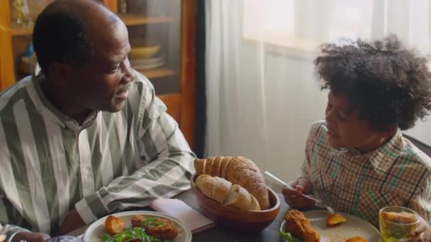 Glada Afroamerikanska Föräldrar Chattar Med Söt Liten Son Hemma Familjemiddag — Stockvideo