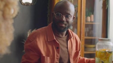 Afrika kökenli Amerikalı bir adamın evde akşam yemeği partisinde bir kadınla konuşması.