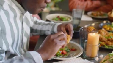 Afro-Amerikan bir adamın evde kızarmış tavuk yediği bir sahne.