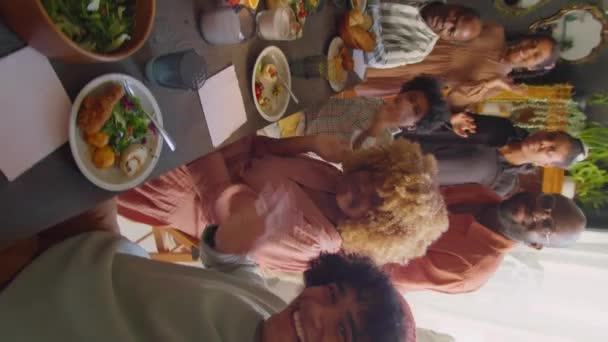 ハメ撮り垂直ショットの幸せなアフリカ系アメリカ人家族一緒に座っていますディナーテーブル 笑顔と手を振ってカメラに取りながら自己撮影やビデオ通話で家のお祝い — ストック動画