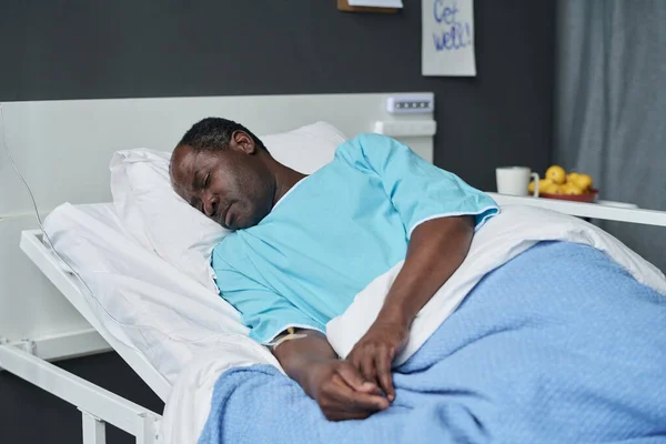 stock image African American man resting on bed in ward during his rehablitation in hospital