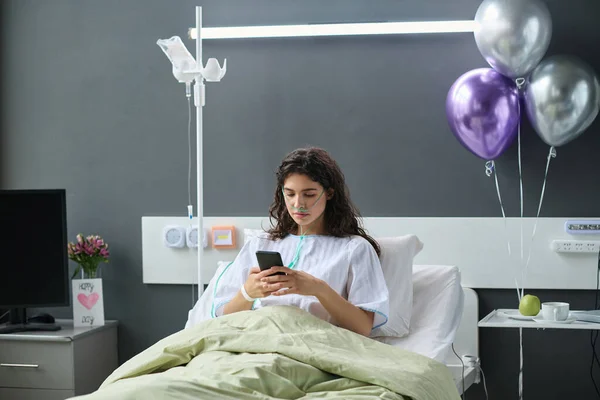 병실에서 풍선으로 장식된 침대에 스마트폰을 사용하는 — 스톡 사진