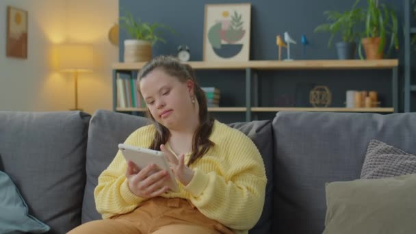 Mädchen Mit Syndrom Sitzt Hause Auf Sofa Und Nutzt Digitales — Stockvideo