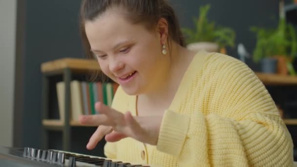 Fröhliches Mädchen Mit Syndrom Lächelt Und Spielt Hause Synthesizer — Stockvideo