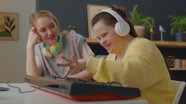 Flicka Med Syndrom Trådlösa Hörlurar Spelar Synt Som Kvinnlig Musiklärare — Stockvideo