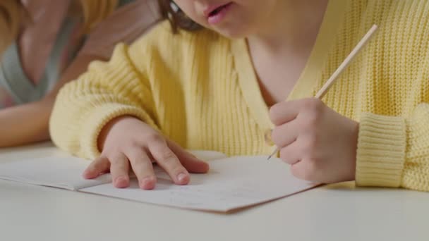 Naklonit Záběr Dívky Downovým Syndromem Psaní Sešitu Stole Při Plnění — Stock video