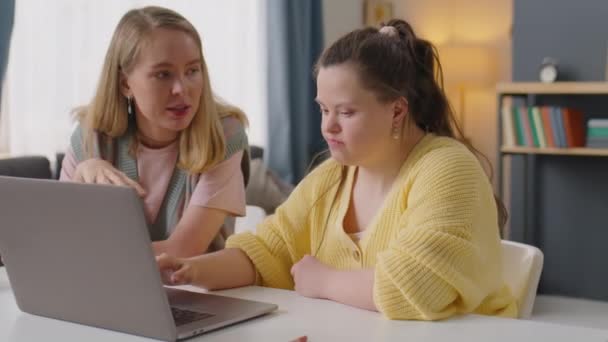 Wesoła Dziewczyna Zespołem Downa Pomocą Laptopa Rozmawia Nauczycielką Podczas Lekcji — Wideo stockowe