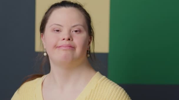 Portrét Veselé Dívky Downovým Syndromem Pózující Pro Kameru Zdi Barevného — Stock video