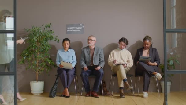 複数の民族経営者が列に並んで待っている間 オフィスでのインタビューのための若い男性候補者を招待女性人事マネージャー — ストック動画