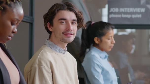 Ofiste Görüşmesi Için Sırada Beklerken Gülümseyerek Poz Veren Neşeli Genç — Stok video