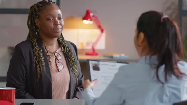 女性のリクルーターにCvを与え オフィスでの仕事のインタビュー中に彼女と話す若いアフリカ系アメリカ人のビジネス女性の追跡ショット — ストック動画