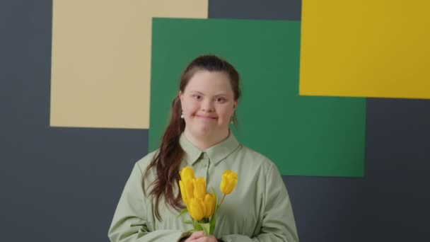 Retrato Menina Alegre Com Síndrome Segurando Buquê Tulipas Amarelas Posando — Vídeo de Stock