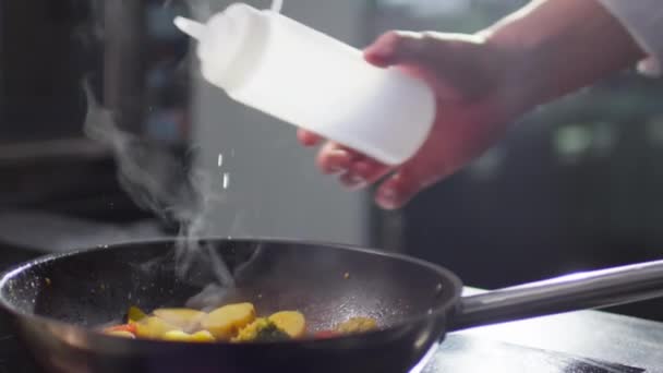 慢动作近距离拍摄男性厨师向油锅里加酒精的手拍 然后用较轻的火种蔬菜点火 — 图库视频影像