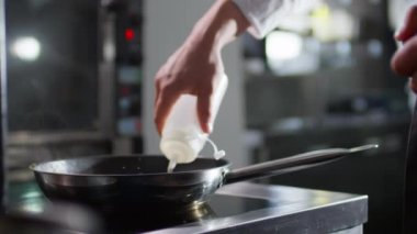 Lokanta mutfağında alev almadan önce profesyonel şefin tavaya alkol koyduğu sahneler.