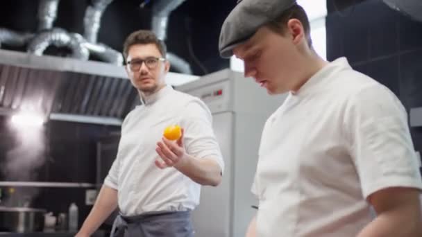 Chef Masculino Uniforme Cortando Cebola Vermelha Falando Com Colega Enquanto — Vídeo de Stock