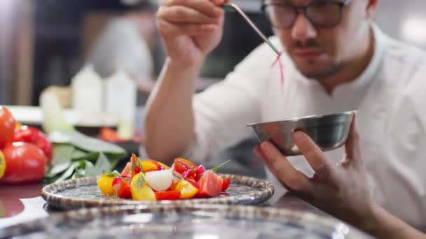 Profesjonalny Kucharz Mundurze Okularach Pomocą Pęsety Przybrania Świeżych Sałatek Pomidorowych — Wideo stockowe