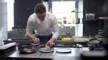 Aşçı restoranda tavada pişirilmiş balık servis ediyor.