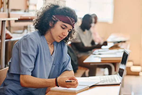 Estudante Medicina Séria Uniforme Sentado Mesa Com Caderno Laptop Ele — Fotografia de Stock
