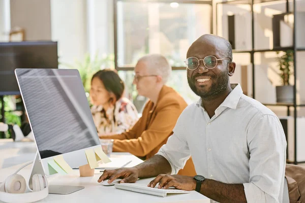 Retrato Programador Africano Óculos Sorrindo Para Câmera Enquanto Trabalhava Computador — Fotografia de Stock