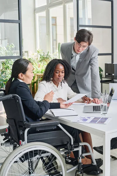 Asian businesswoman with disability working with her colleagues at meeting at office