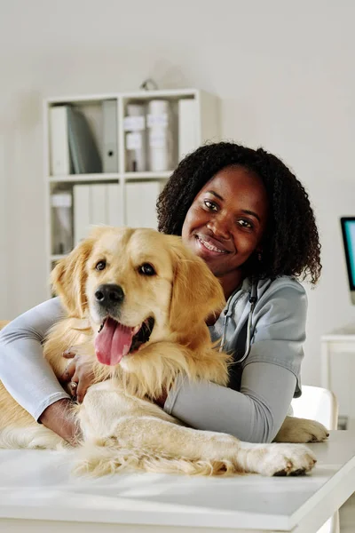 アフリカの獣医の医師の肖像笑顔でカメラで受け入れながら取得犬でクリニック — ストック写真