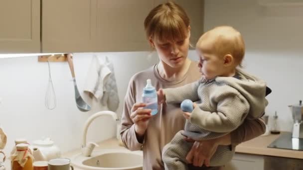 Mother Holding Baby Son Arms Giving Him Feeding Bottle Water — Stock Video
