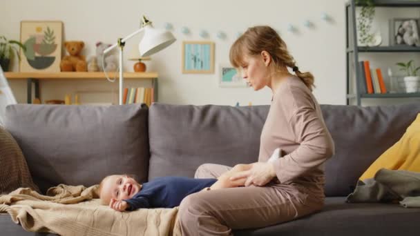 Joyful Mother Playing Baby Son Tickling Him Sofa Home — Stock Video