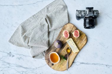 Yüksek açılı ahşap tepsi, egzotik meyveler ve bal fotoğraf makinesinde profesyonel çekim için hazırlanıyor.