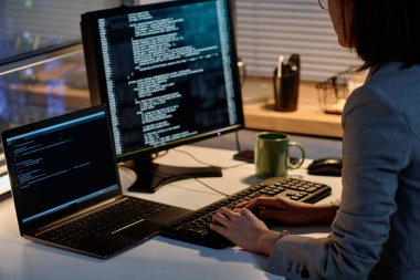 Bilgisayarda güvenlik kodlarıyla çalışan kadın programcının yakın plan görüntüleri karanlık ofisinde oturuyor.
