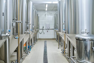 İçki demlemek için içinde sıvı bulunan çelik varillerle dolu bir deponun yatay görüntüsü.