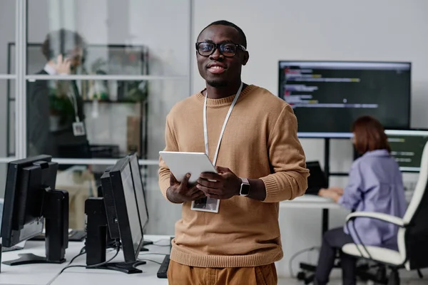 非洲裔美国信息技术专家在数码平板电脑上工作时对着摄像机微笑的肖像 — 图库照片