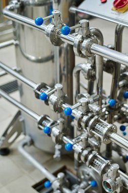 Üretim fabrikasında manivelalı metal boru hattı olan makinelere yakın çekim.