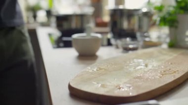 Şefin ahşap kesme tahtasına bir demet taze maydanoz koyarkenki yakın çekimi.