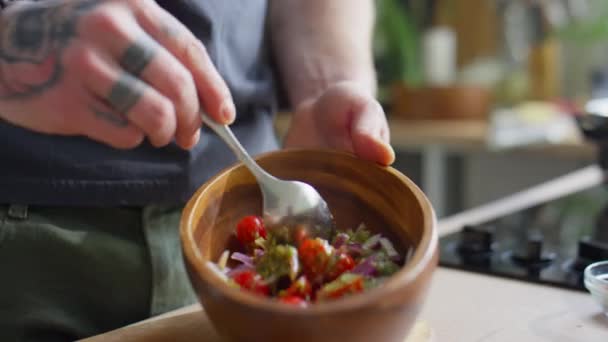 男性厨师用勺子把新鲜蔬菜沙拉和平底锅调料混合在一起的特写镜头 — 图库视频影像