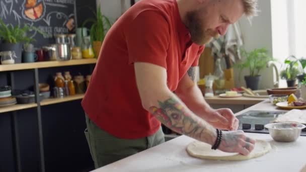大胡子男厨师在准备披萨时把面团倒在厨房桌子上 — 图库视频影像