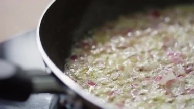 Kırmızı soğan ve sarımsağın tavada kızardığı yakın çekim.