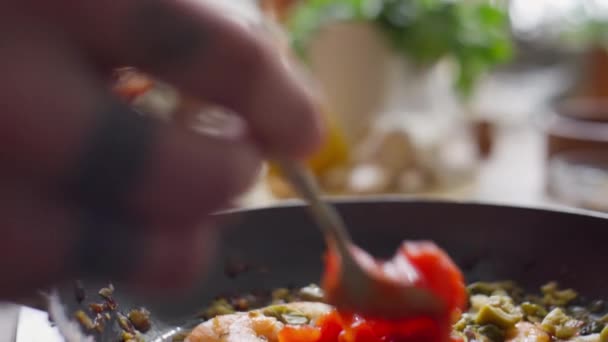 フライパンで具材にスプーンでトマトを追加シェフの手のショットを閉じます — ストック動画