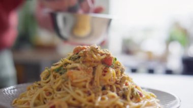 Erkek eli yakından çek. Tabakta servis edilen lezzetli karidesli spagetti ekle.