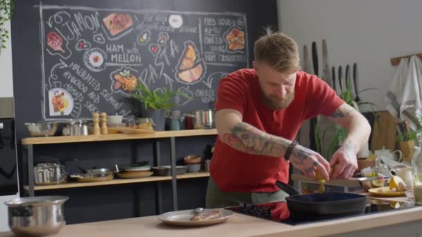 大胡子的男厨师在厨房做饭的时候 把土豆放在烤盘里放在炉子上 — 图库视频影像