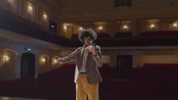 排练期间 在空旷的音乐厅舞台上弹奏小提琴的年轻有才华的非洲裔美国小提琴手的镜头放大放大了 — 图库视频影像