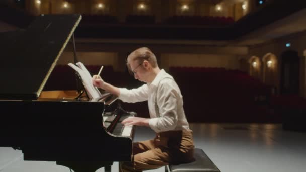 在空旷的音乐厅舞台上 专业作曲家用大钢琴谱写乐谱的镜头放大 — 图库视频影像