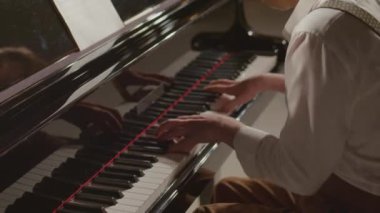 Profesyonel piyanistin konser salonu sahnesinde müzik çalarken çekilen çekimleri.