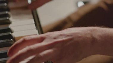Müzik çalarken piyano tuşlarına basan erkek piyanistin ellerini yakın çekimde çek