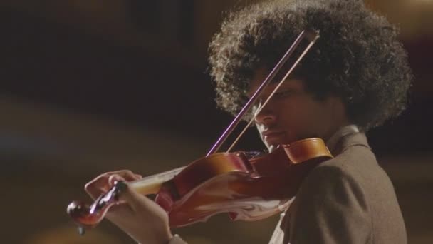 低角度選択的フォーカスショットの若いアフリカ系アメリカ人バイオリニスト演奏フィドル中クラシック音楽コンサート — ストック動画
