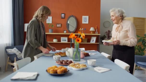 Powiększ Ujęcie Młodej Kobiety Pomagającej Starszej Babci Serwować Jedzenie Stole — Wideo stockowe