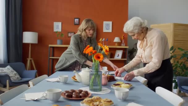 让更多快乐的年轻女性和年长的祖母讨论一些事情 并为家里的家庭庆祝准备节日餐桌 — 图库视频影像