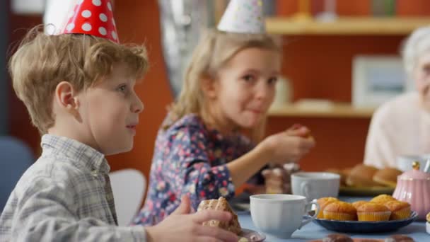 Parti Şapkalı Yaşlı Kadın Yemek Masasında Oturuyor Küçük Torunuyla Aile — Stok video