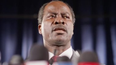 Basın toplantısı sırasında Afrikalı Amerikalı politikacının TV mikrofonlarında konuştuğu düşük açılı görüntüler.