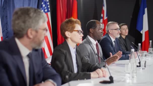 Rack Focus Shot Πολυεθνικών Διπλωματών Που Κάθονται Στο Τραπέζι Των — Αρχείο Βίντεο